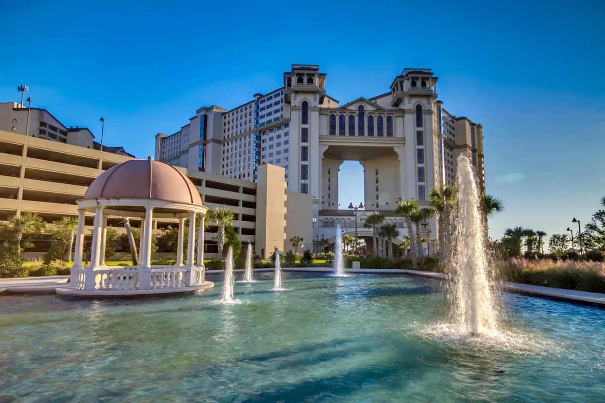 A stately exterior features landscaped gardens, a charming water fountain, and a gazebo overlooking the property. The scene evokes a sense of upscale tranquility and is ideal for social gatherings or quiet moments by the water.