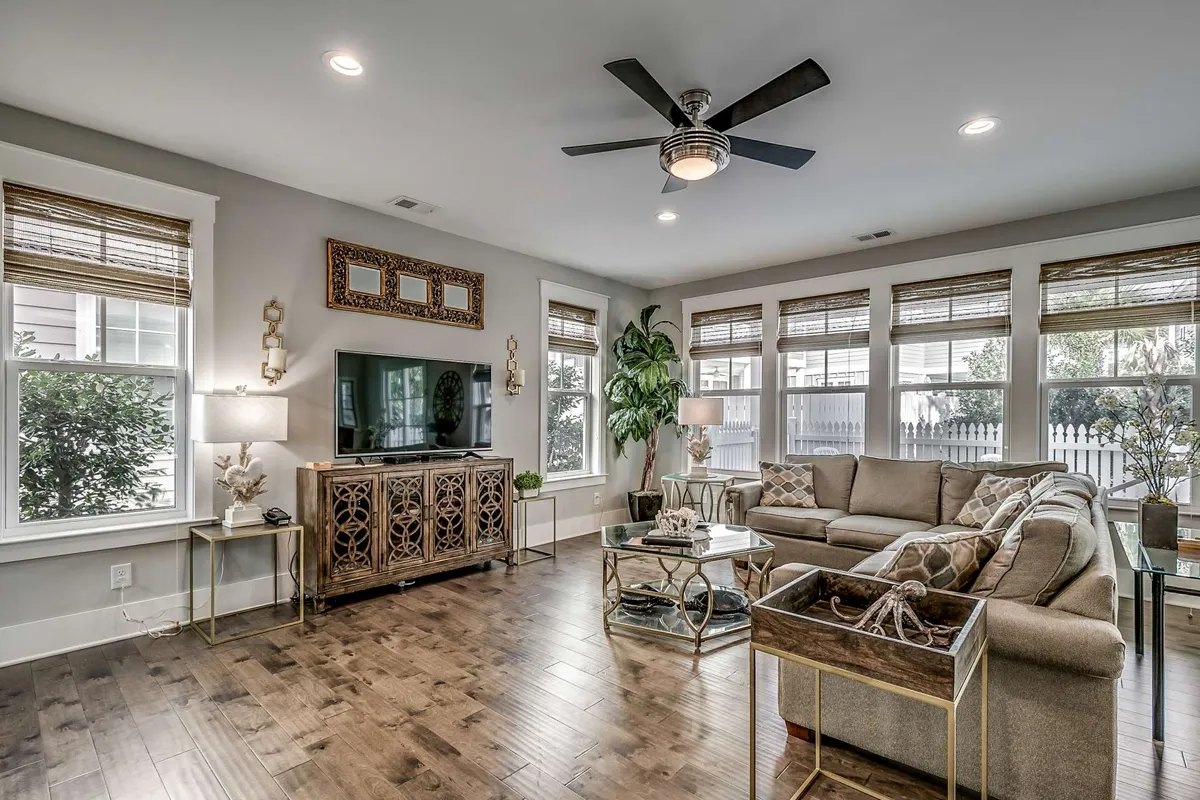A cozy living area featuring a large, comfortable sectional sofa, a stylish coffee table, decorative cabinetry, and expansive windows that flood the space with natural light. The room feels both inviting and functional, ideal for family relaxation or lively gatherings.